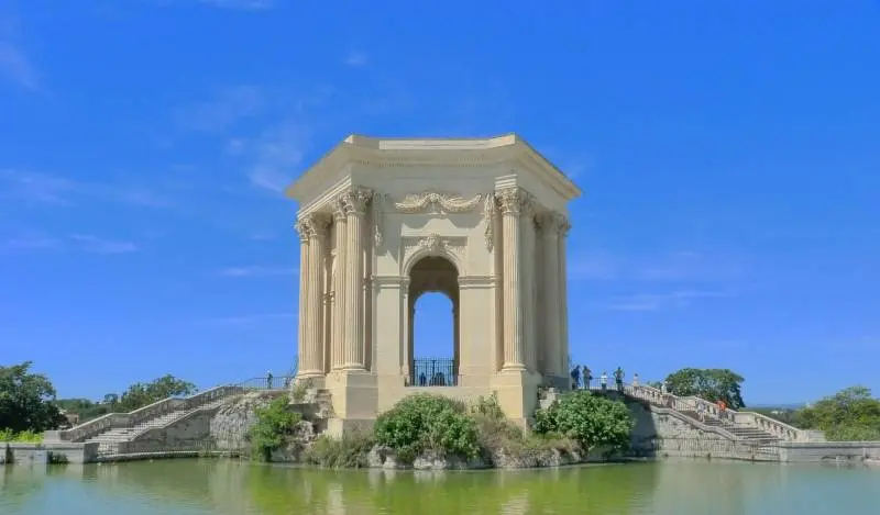Château d’eau du Peyrou in Montpellier with blue sky and reflection in the water