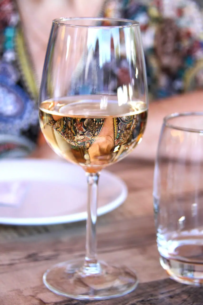 Close-up of a glass of white wine reflecting colours and patterns at a French restaurant