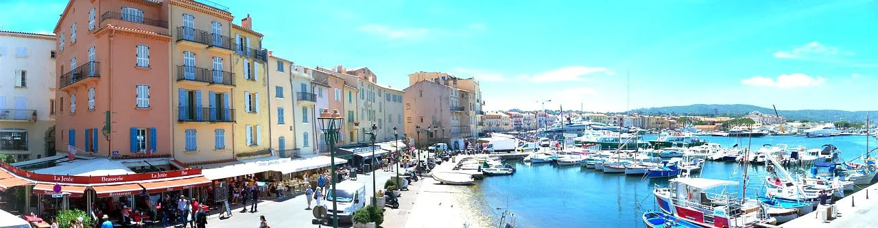 Colourful harbour with boats and cafés in a sunny French coastal town