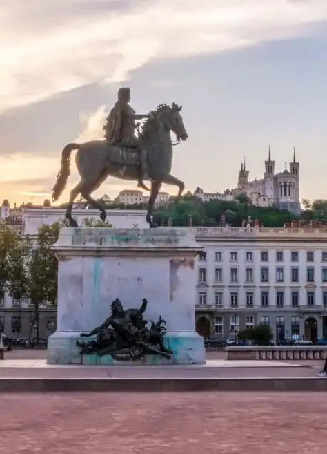 Equestrian statue of Louis XIV on Place Bellecour in historic Lyon with Fourvière hill in the background – French language school in Lyon