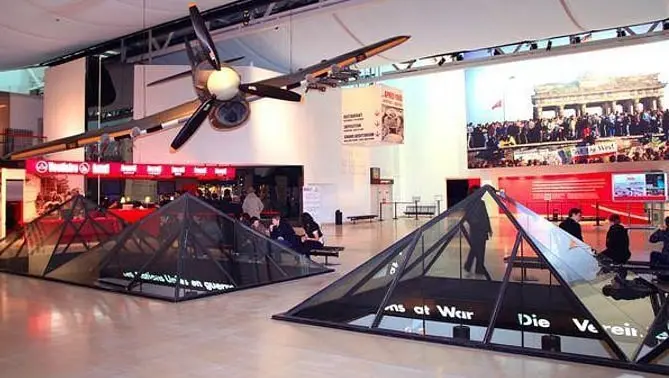 Interior of the Caen Memorial Museum with WWII exhibitions and visitors exploring the permanent collections