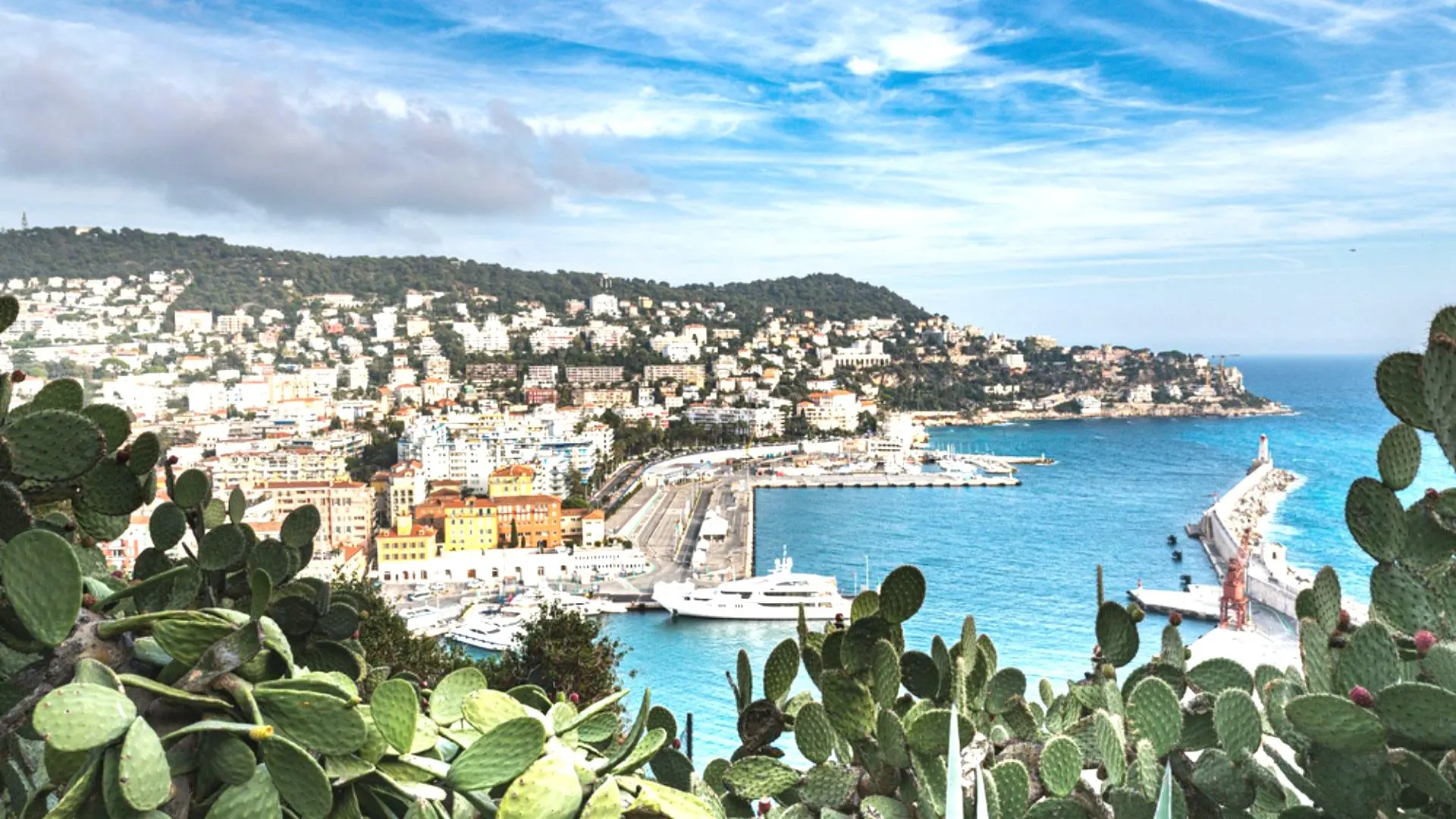 Panoramic view of the Port of Nice and the French Riviera coastline, with yachts and Mediterranean architecture