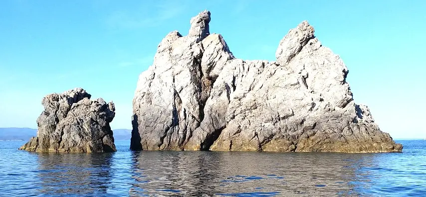 Rocky islets rising from the Mediterranean Sea under a clear blue sky