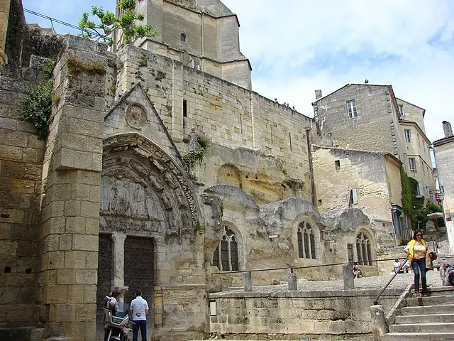 Tourists at the carved stone entrance of the monolithic church in Saint-Émilion, France