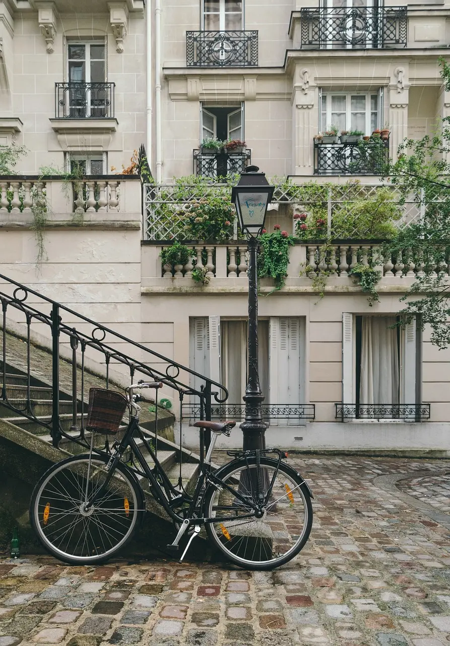 Typical Parisian street with a bicycle, cobblestones and elegant Haussmann-style balconies