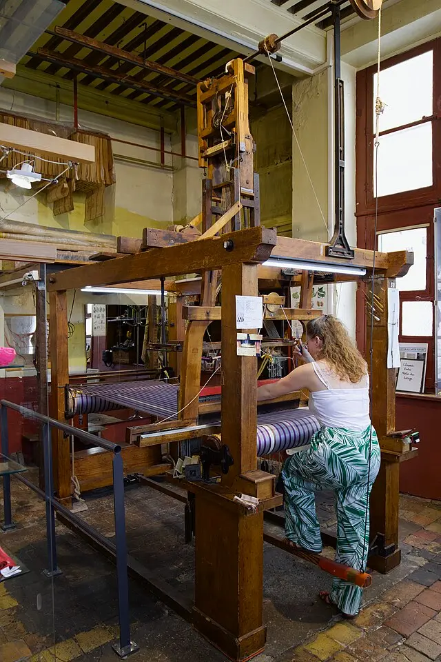 Weaver operating a traditional Jacquard loom in a Lyon silk workshop