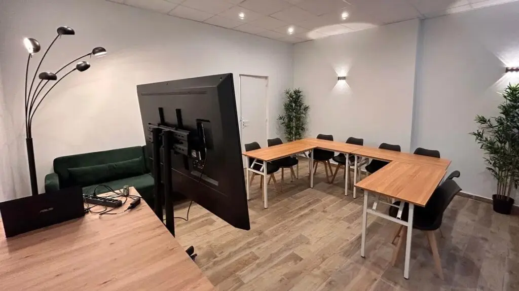 Modern classroom at a French language school in Lyon with U-shaped desks and a large screen