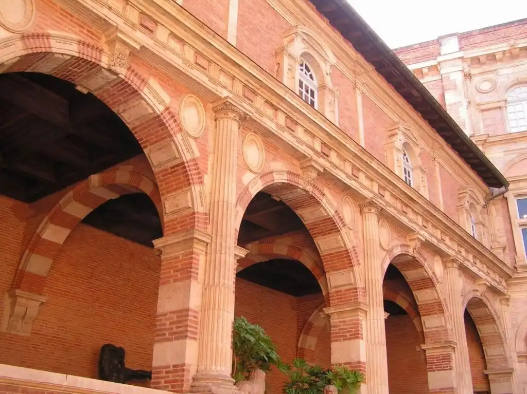Pink brick arches of a Renaissance courtyard in Toulouse, France