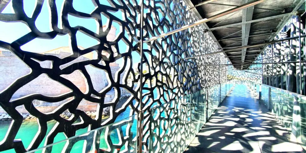 View of the Mucem footbridge in Marseille with modern lattice architecture and sea in the background