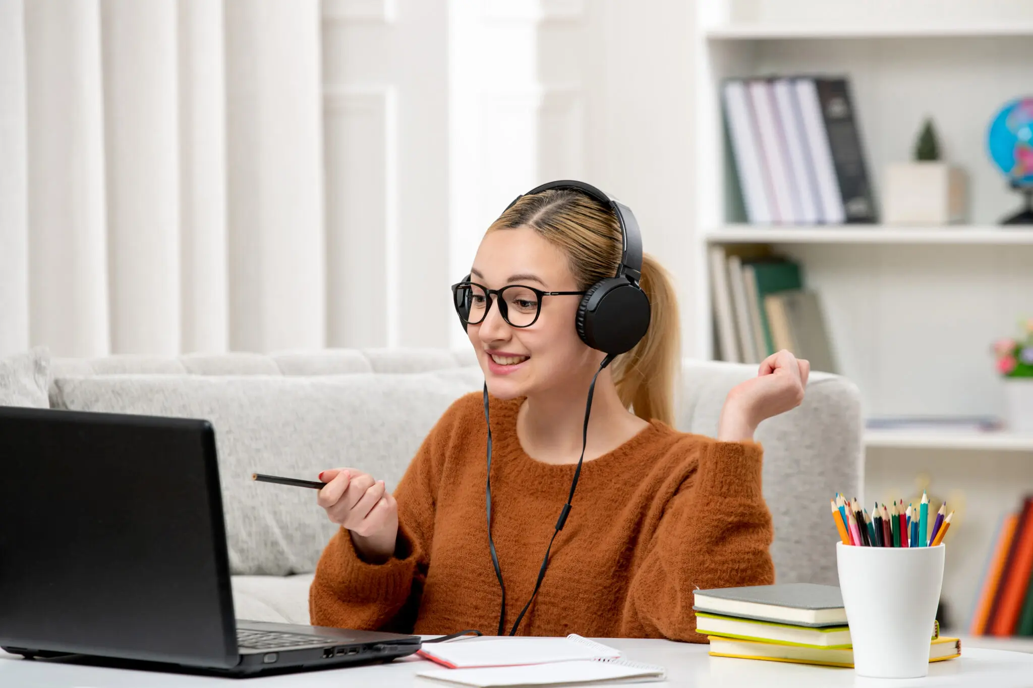 Young woman learning French online with headphones and laptop – French classes from home